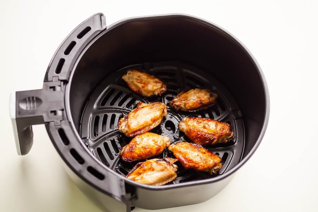 Crispy chicken wings cooking in an air fryer. What can you cook in an air fryer? Perfect wings.