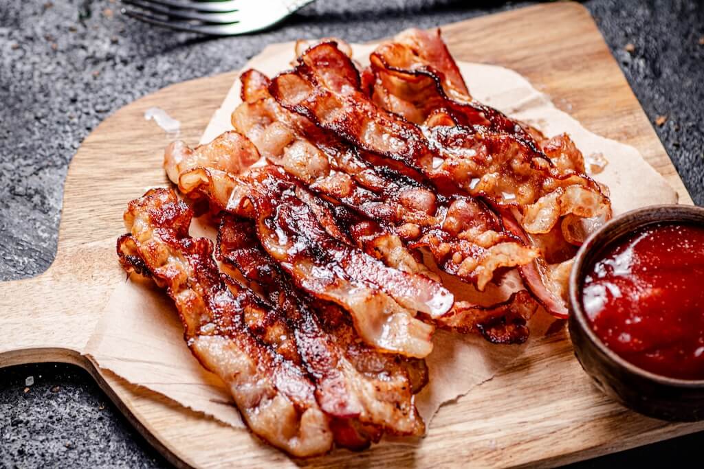 Plate of crispy fried bacon, an example of what can you cook in an air fryer.